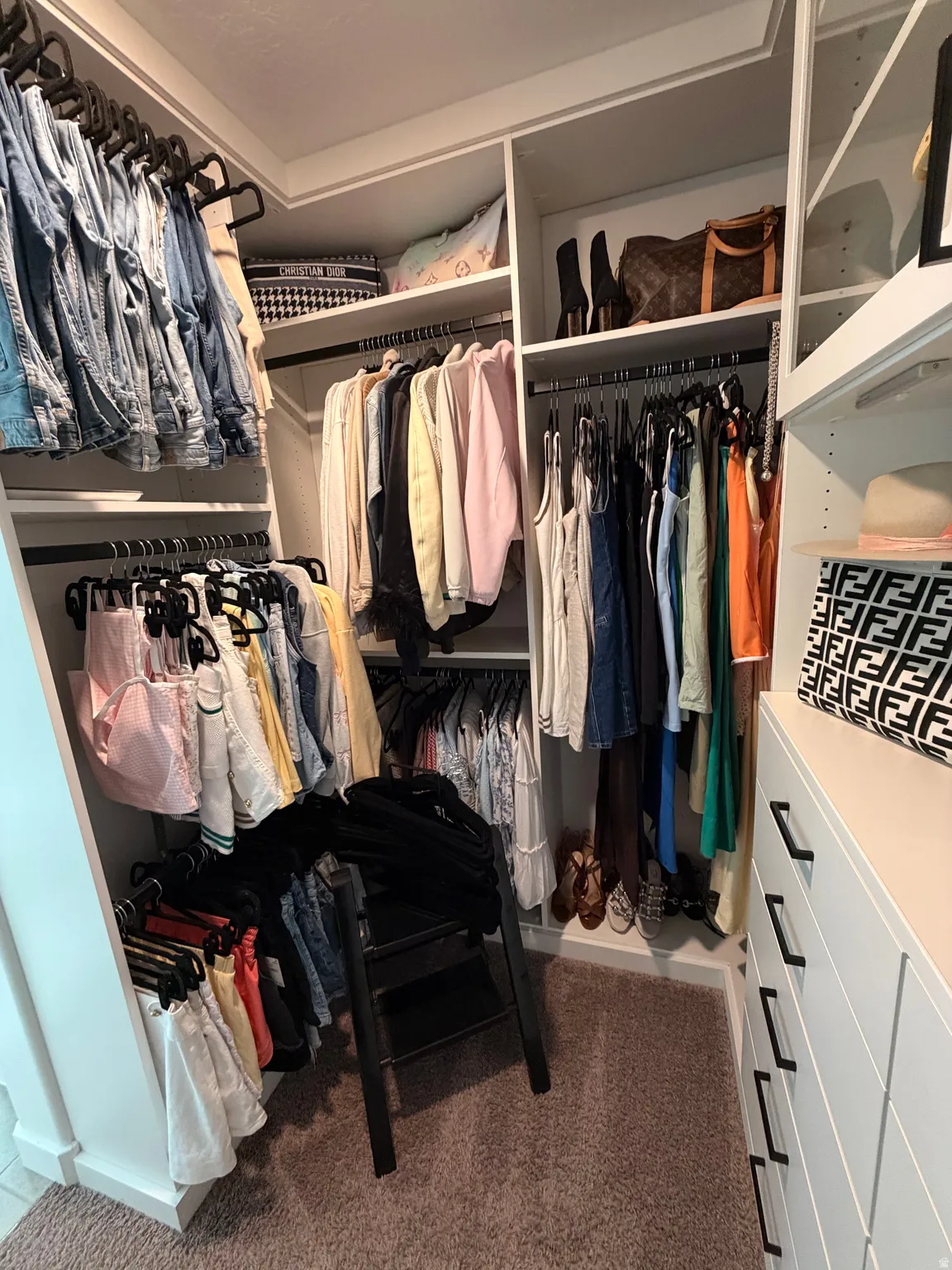 Custom closet system featuring built-in shelving, multiple hanging rods, and integrated drawer storage