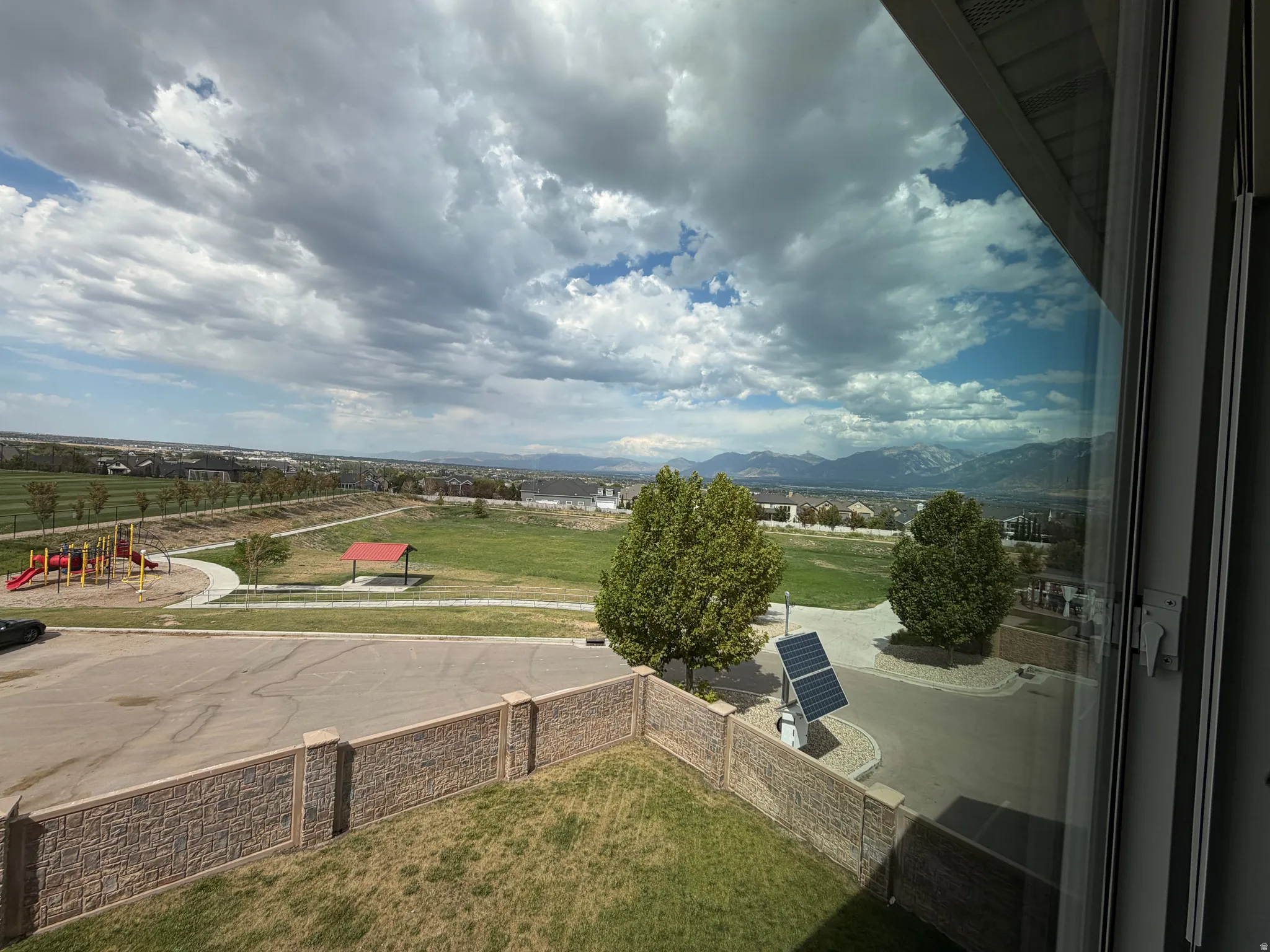 Expansive community green space with playground, paved walking paths, and a covered pavilion
