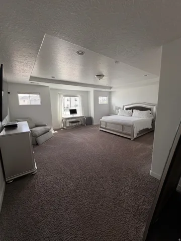 Recessed lighting and a tray ceiling complement a neutral color palette