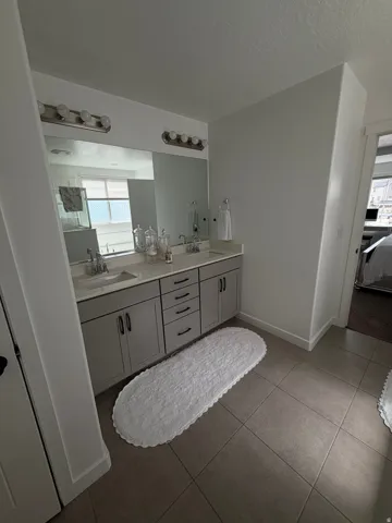 Dual vanity with undermount sinks, gray shaker-style cabinetry, and brushed nickel hardware