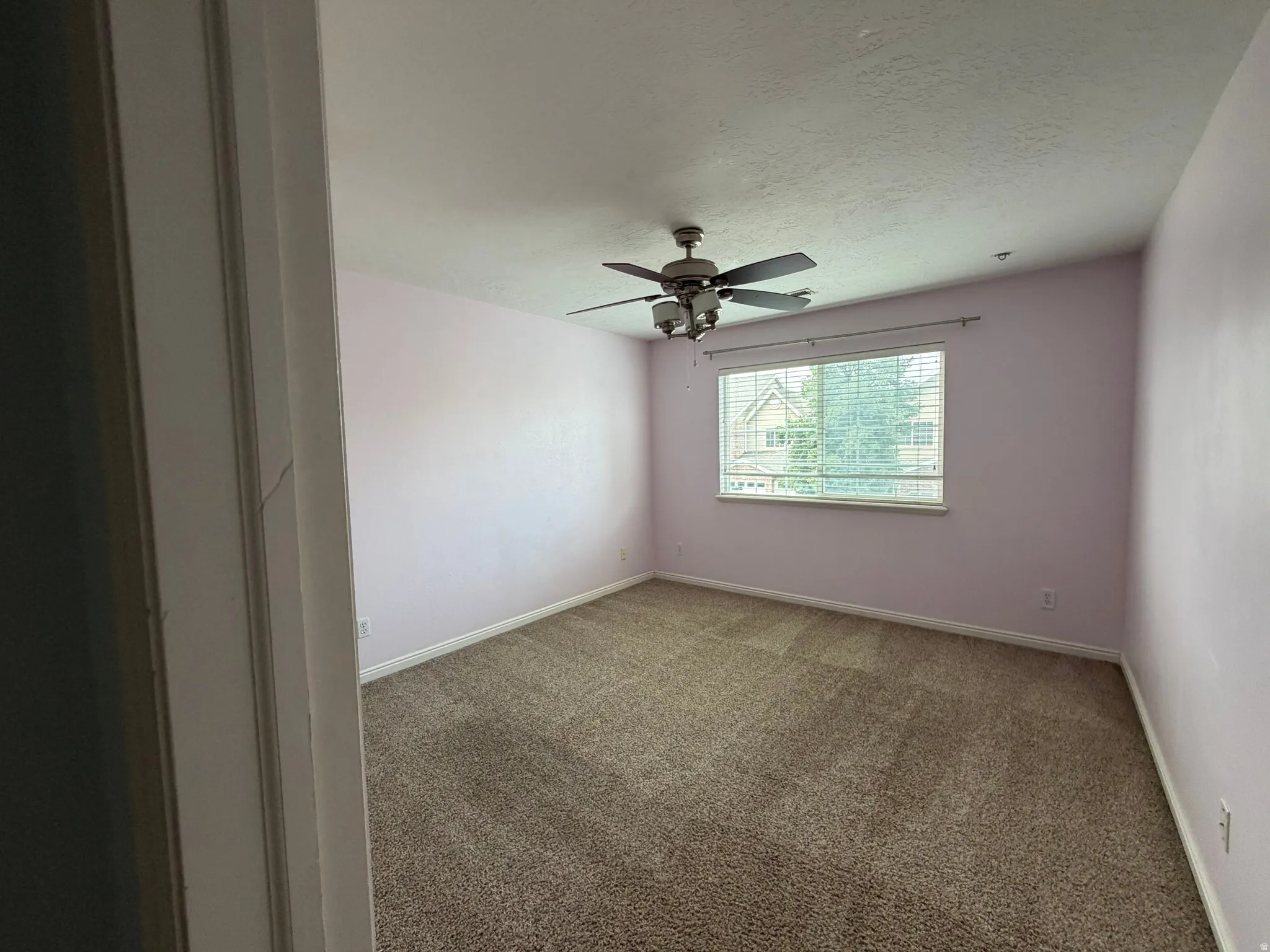Carpet flooring, window with blinds, ceiling fan with integrated lighting, white trim
