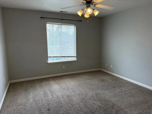 Carpeted flooring, neutral wall paint, window with blinds, ceiling fan, and overhead lighting