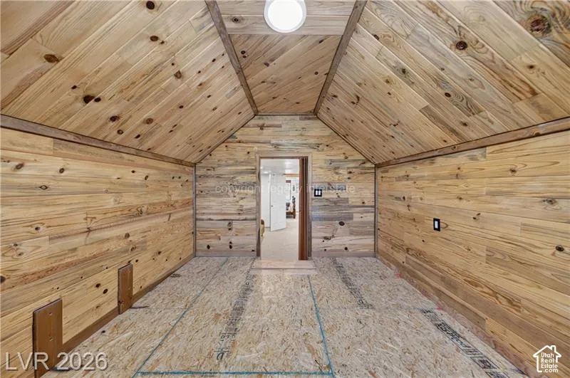 Vaulted wood-paneled ceiling, wood-paneled walls, and recessed lighting