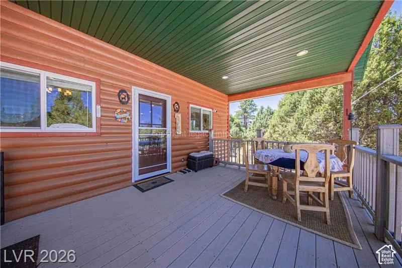 Covered porch with wood-finish siding, wood-finish flooring, and a green ceiling