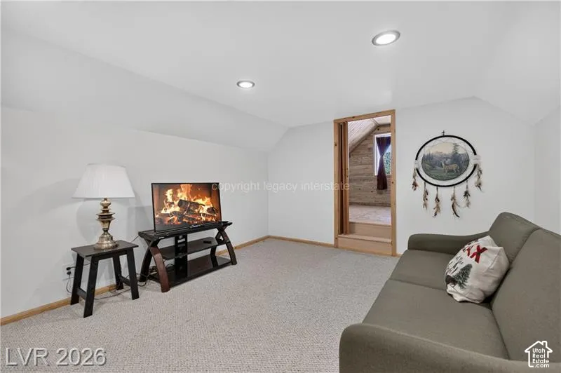 Carpeted room with recessed lighting and sloped ceilings