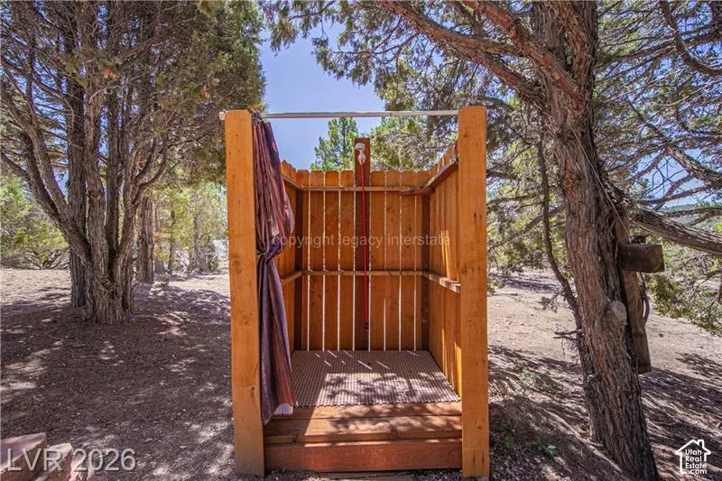Outdoor shower structure featuring natural wood construction and a slatted floor