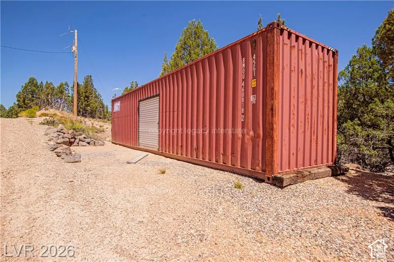Red corrugated metal storage container with a roll-up door
