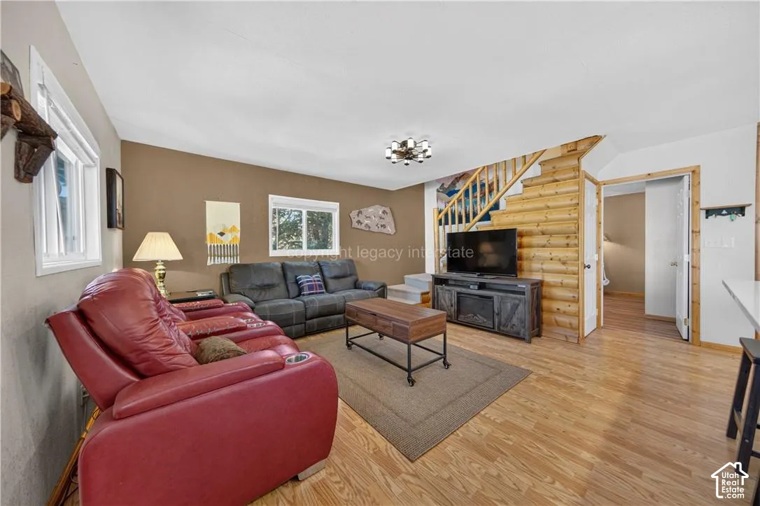 Wood-finish flooring throughout, light neutral walls, and a built-in log wall feature