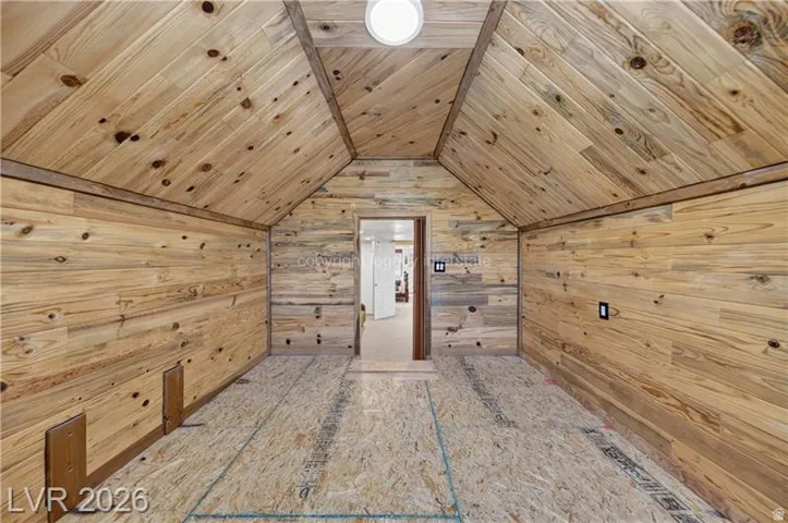 Vaulted wood-paneled ceiling, wood-paneled walls, and recessed lighting