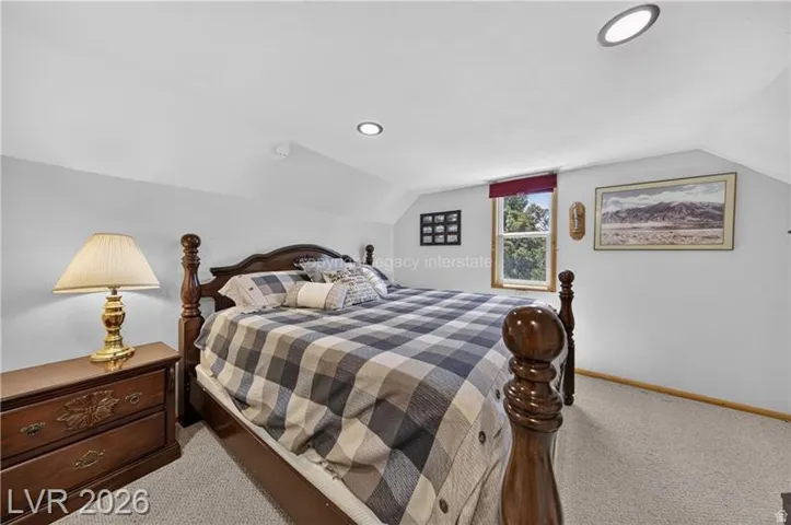 Carpeted flooring, window with red valance, recessed ceiling lighting, and sloped ceiling