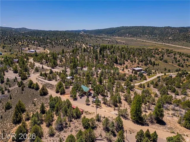 Expansive property featuring a scattered tree landscape, multiple structures, and unpaved roads