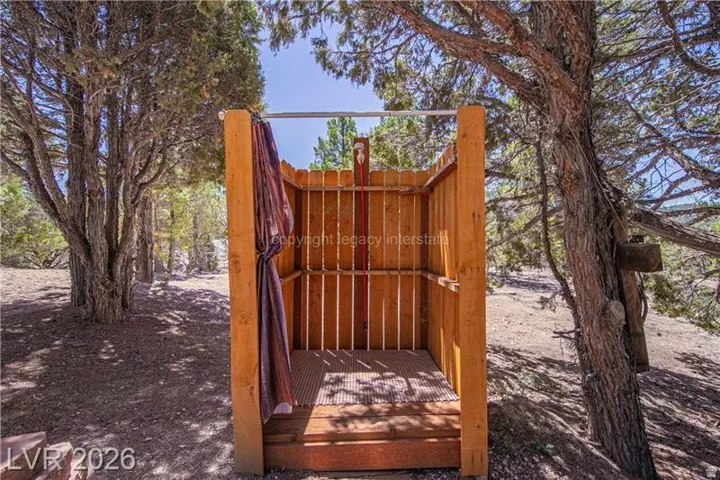 Outdoor shower structure featuring natural wood construction and a slatted floor