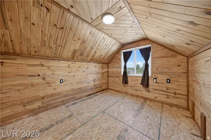 Tongue-and-groove wood paneling, sloped wood-paneled ceiling, recessed window, flush-mount ceiling light