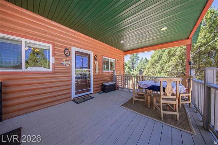 Covered porch with wood-finish siding, wood-finish flooring, and a green ceiling