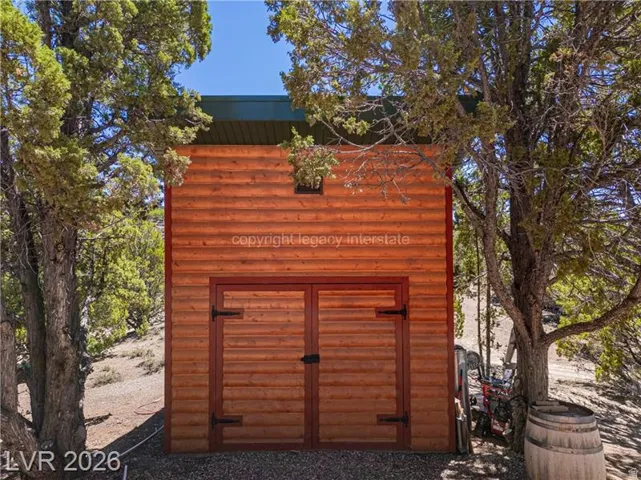 Wood-sided exterior featuring double doors with dark hardware and a window
