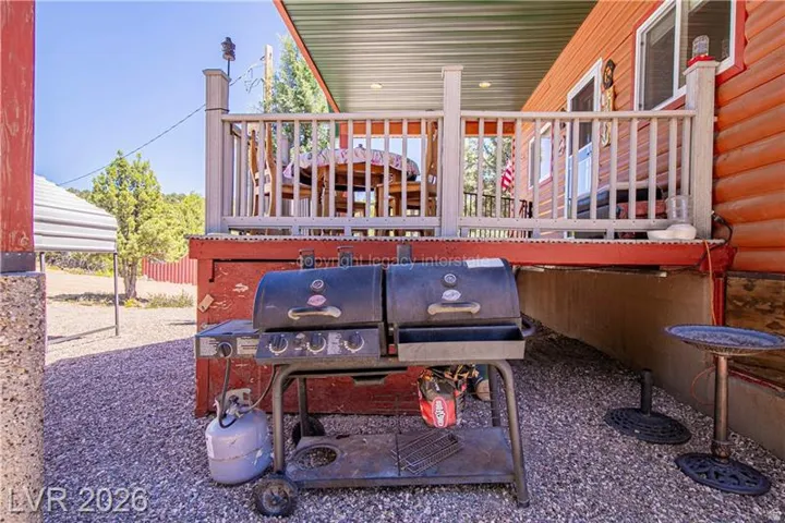 Exterior featuring a covered patio, railing, and rough-hewn wood siding