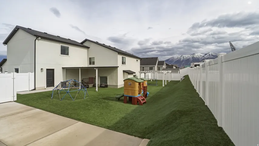 Expansive backyard featuring a manicured lawn, a concrete patio, and a covered outdoor area