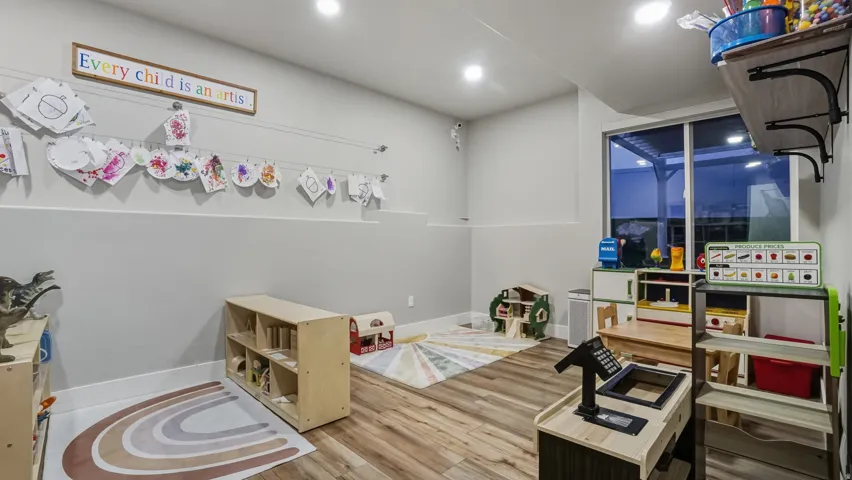Recessed lighting, wood-finish flooring, and a large window providing outdoor access