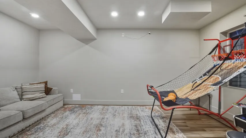 Recessed lighting, light gray walls, wood-finish flooring, and white trim molding