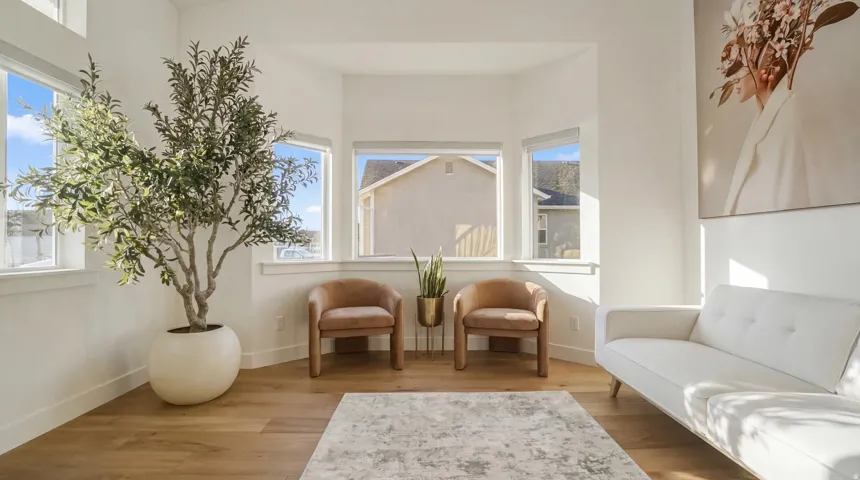 Bay window with multiple windows, light wood-finish flooring, and white walls