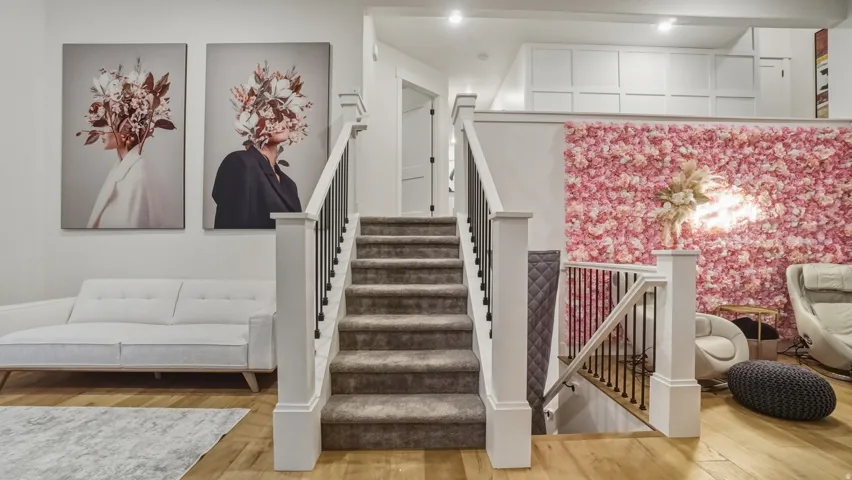 Hardwood flooring, carpeted staircase, white newel posts, black iron balusters, recessed lighting