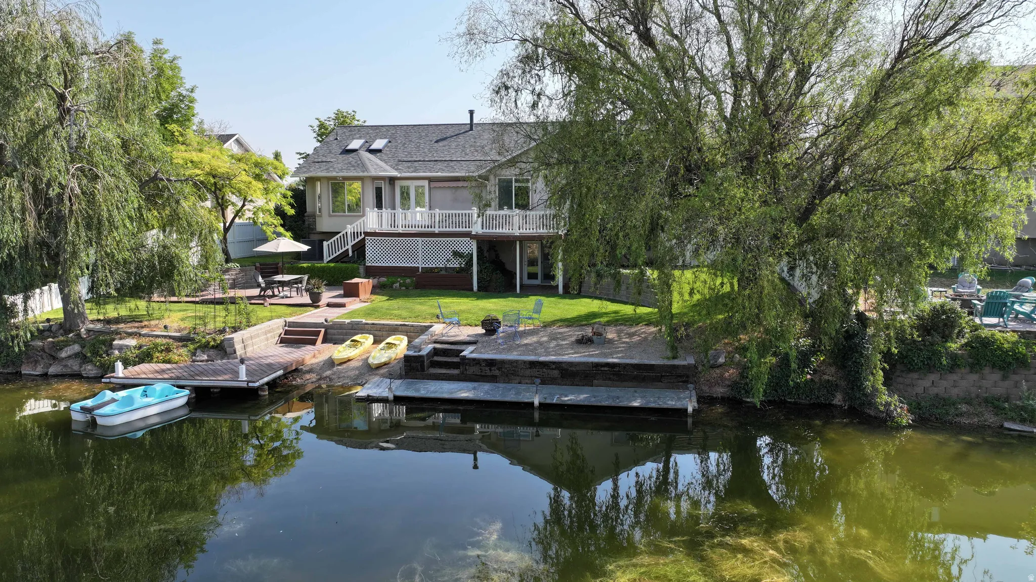 Waterside property with two private docks, a tiered patio, and a spacious deck