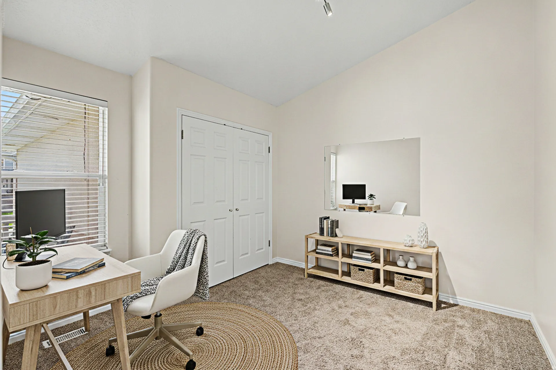 Virtually Staged office/flex space with closet, could serve as a bedroom with Vaulted ceiling, neutral wall paint, window with blinds, carpet flooring, and double bi-fold closet doors