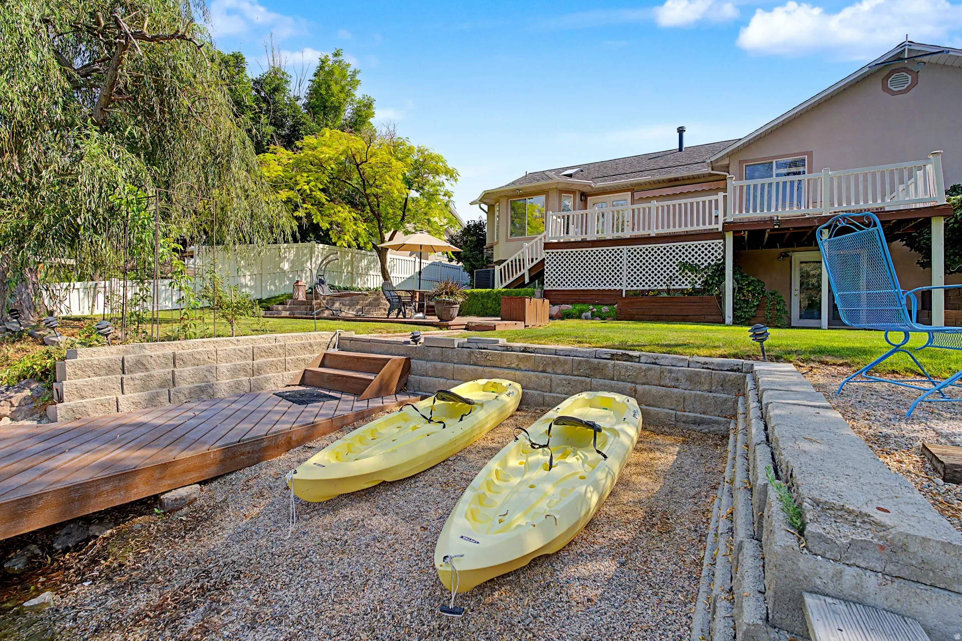 Tiered retaining walls, direct water access, and a multi-level deck with white railings