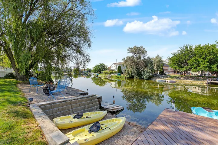 Waterfront property with direct water access, a wood dock, and a stone retaining wall