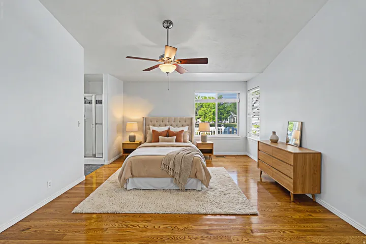 Virtually staged owners suite with beautiful wood flooring, walk in closet and owners bathroom featuring jetted tub and separate shower