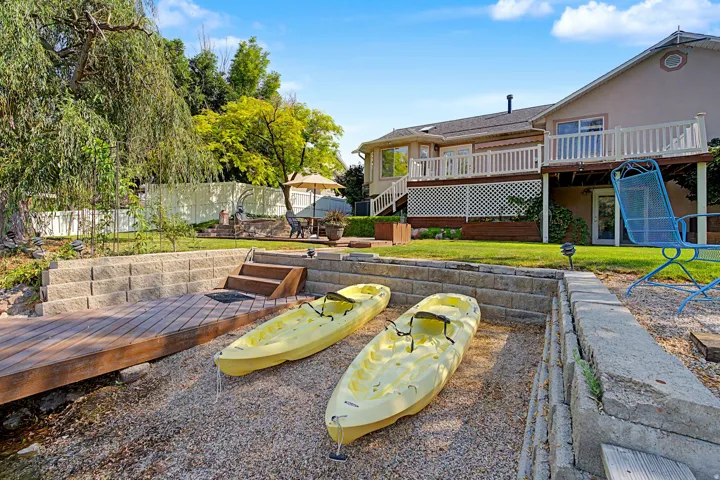 Tiered retaining walls, direct water access, and a multi-level deck with white railings