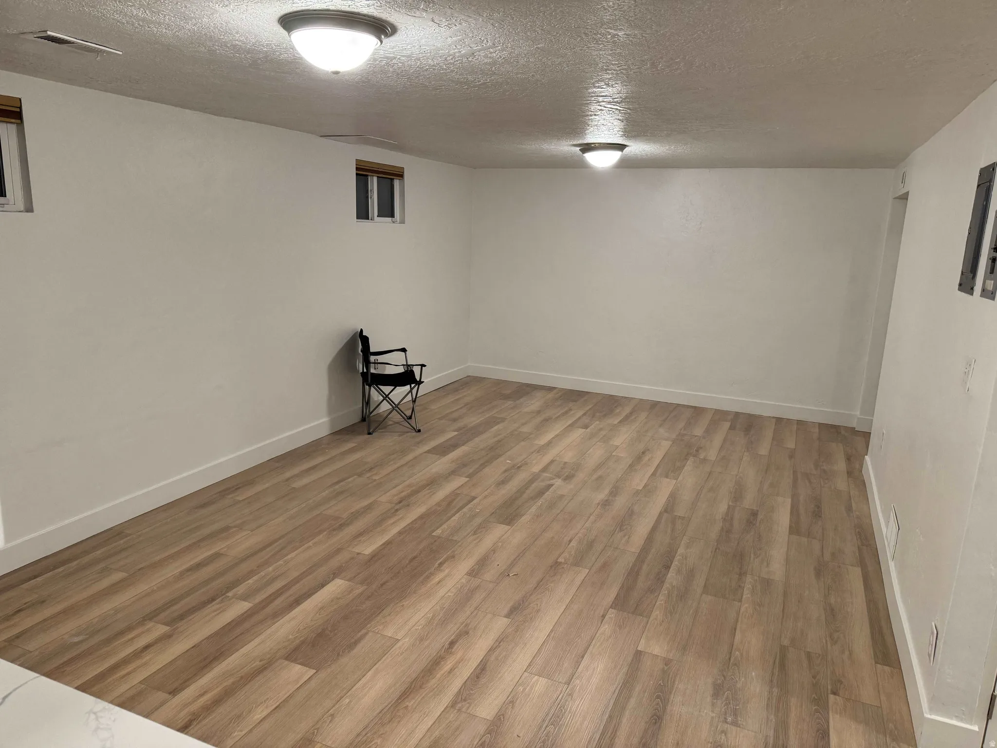 Recessed windows with wood-finish blinds, wood-finish flooring, and flush-mount ceiling light fixtures