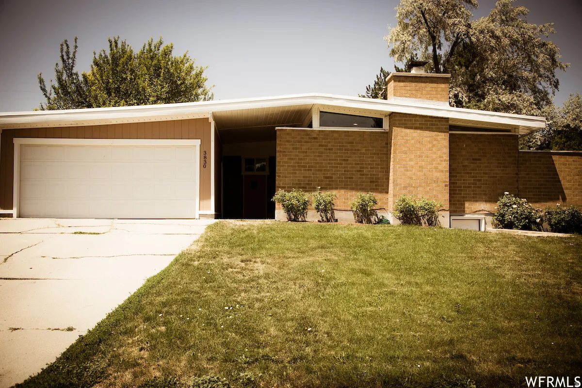 Brick and siding exterior with an attached garage and a sloped roofline