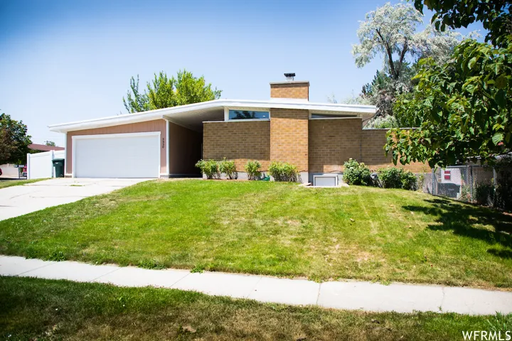 Mid-century modern facade with brick accents and a prominent chimney