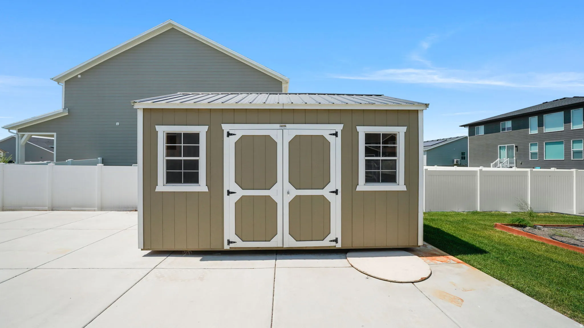Storage shed with dual doors, two windows, and a metal roof