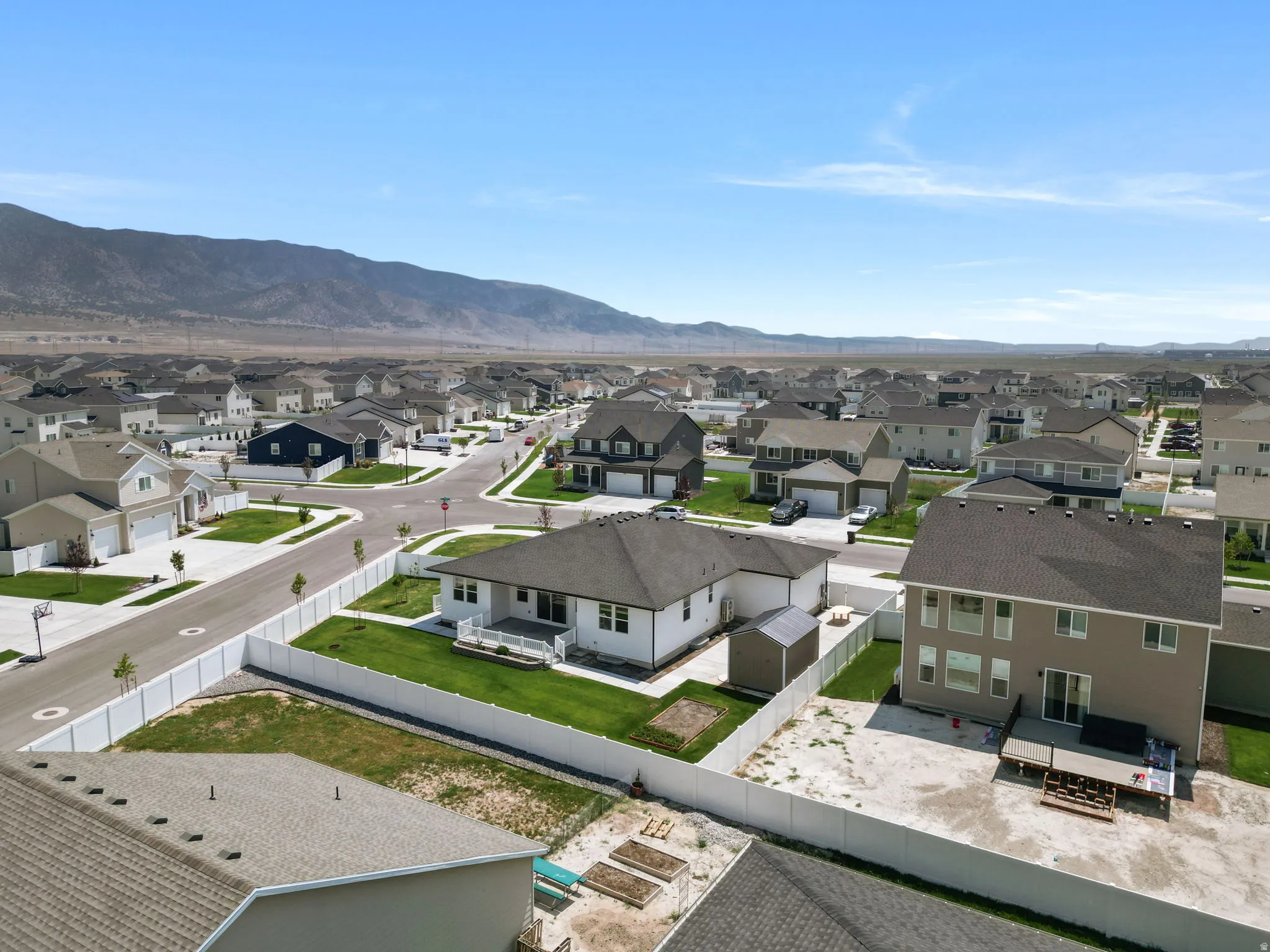 Expansive neighborhood with a consistent architectural style, mountain backdrop, and clear skies