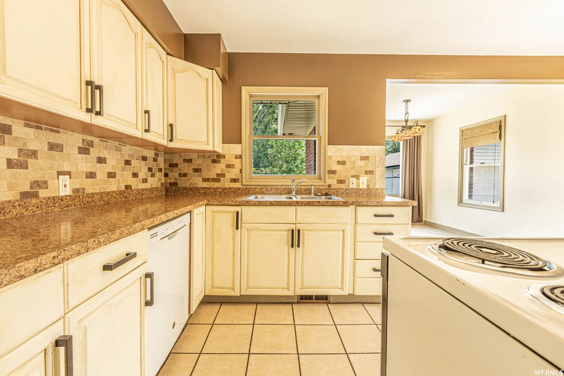 Kitchen featuring stone-finish countertops, tiled backsplash, and ceramic tile flooring