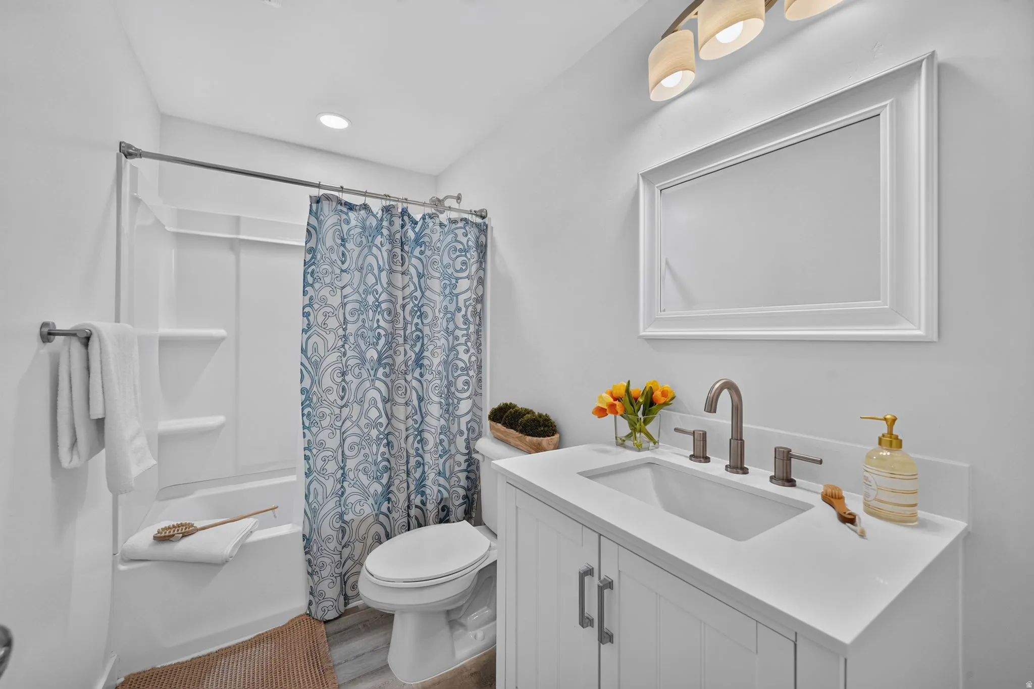 White vanity with a single basin sink and a dark-toned faucet