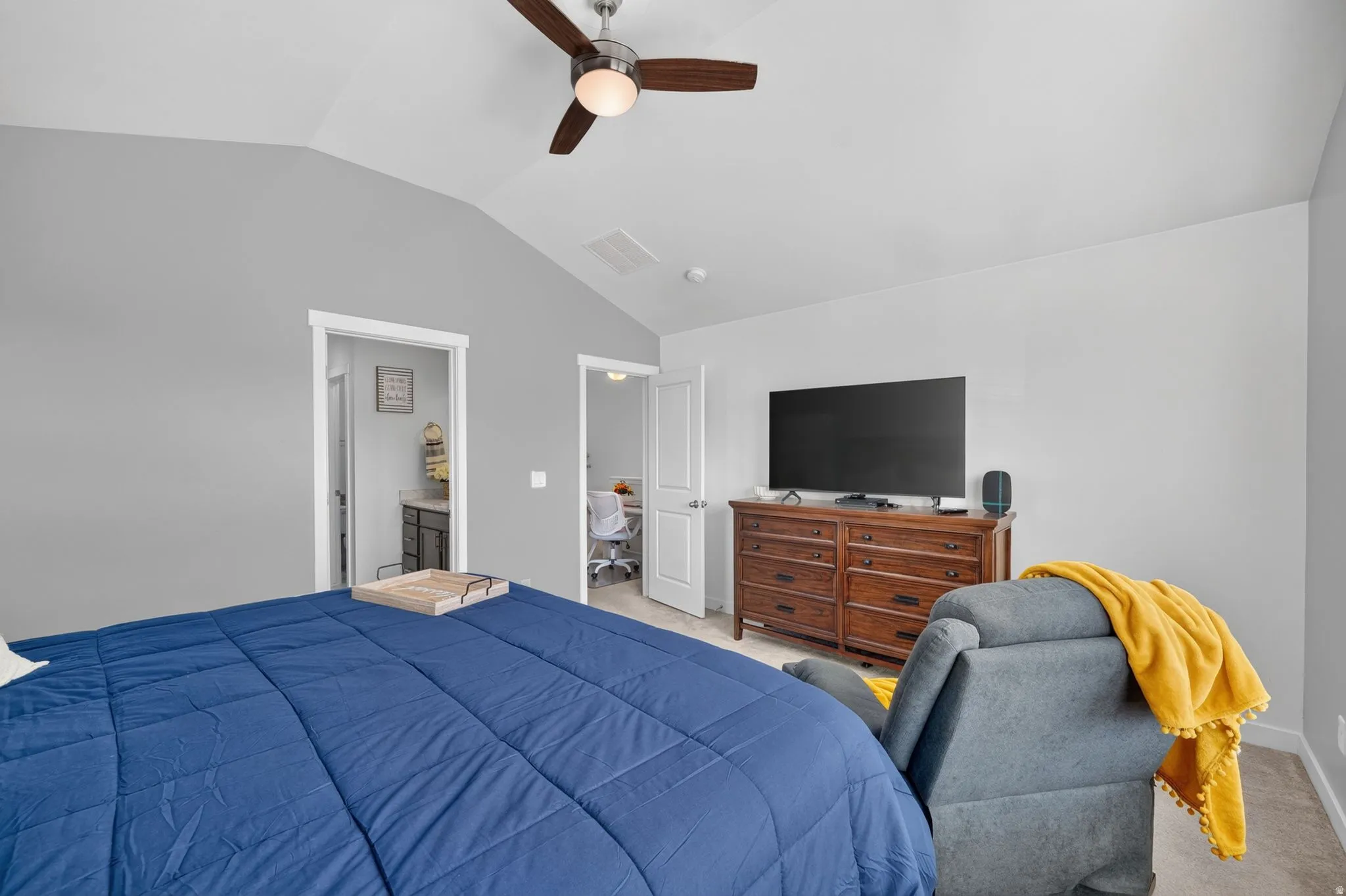 Vaulted ceiling with a ceiling fan and light fixture, light gray wall paint, and white trim