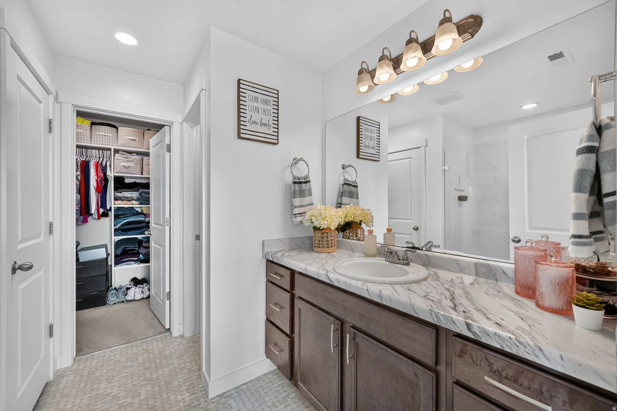 Vanity with a single basin sink, integrated countertop, and wood-finish cabinetry