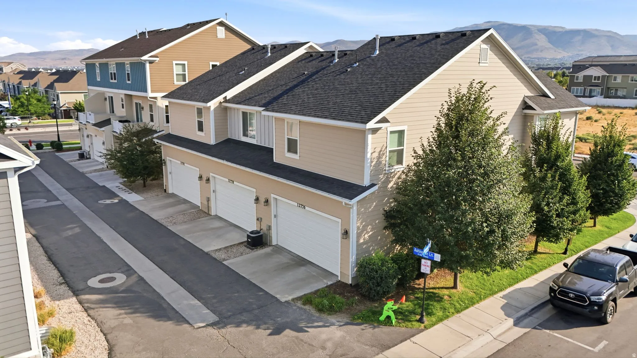 Residential building with light-toned siding, dark shingle roofing, and multiple garage doors
