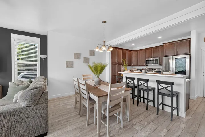 Well-appointed kitchen featuring wood-finish cabinetry, stainless steel appliances, and a built-in breakfast bar