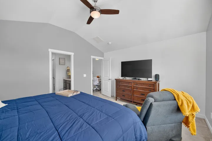 Vaulted ceiling with a ceiling fan and light fixture, light gray wall paint, and white trim