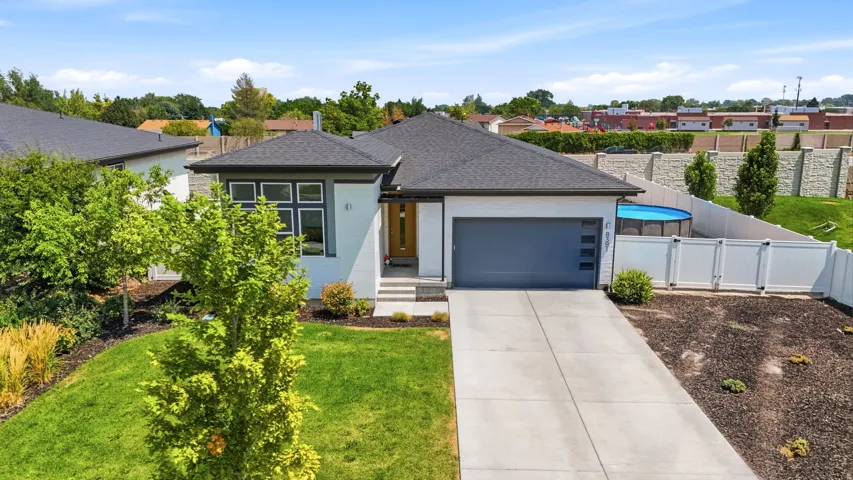 Modern exterior with a dark shingle roof, attached garage, and a concrete driveway