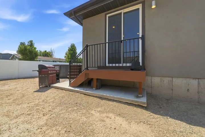 Rear deck with composite decking, black metal railing, and concrete pad