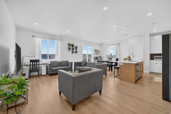 Open-concept living space featuring wood-finish flooring, recessed lighting, and white walls
