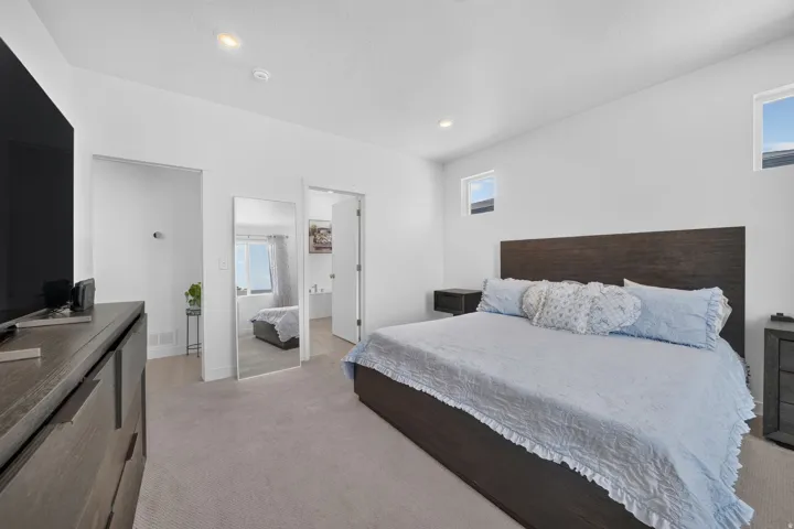 Carpeted room with recessed lighting, multiple windows, and two doorways