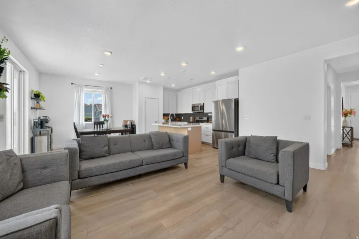 Open-concept living area featuring wood-finish flooring, recessed lighting, and a sliding glass door