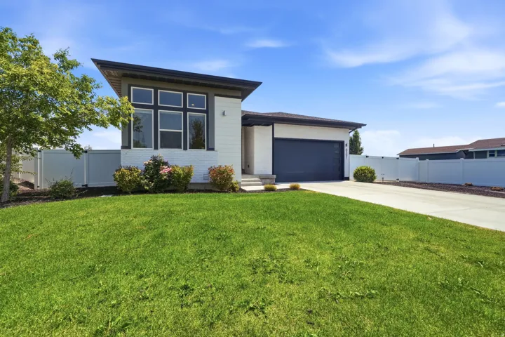 Modern exterior featuring a dark gray garage door, white siding, and a white brick facade