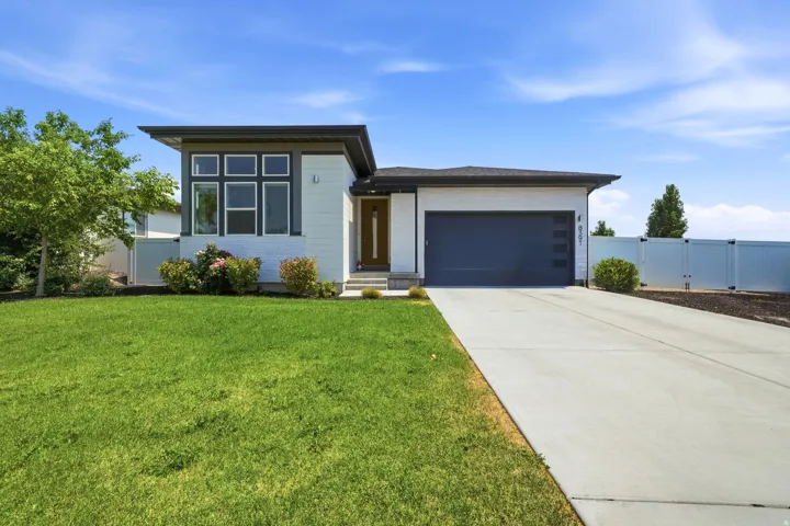 Contemporary exterior with a flat roofline, white siding, and a dark garage door